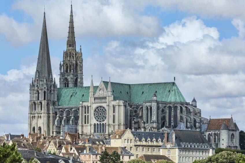 A historic cathedral with twin spires, a large rose window, and a green roof. 4