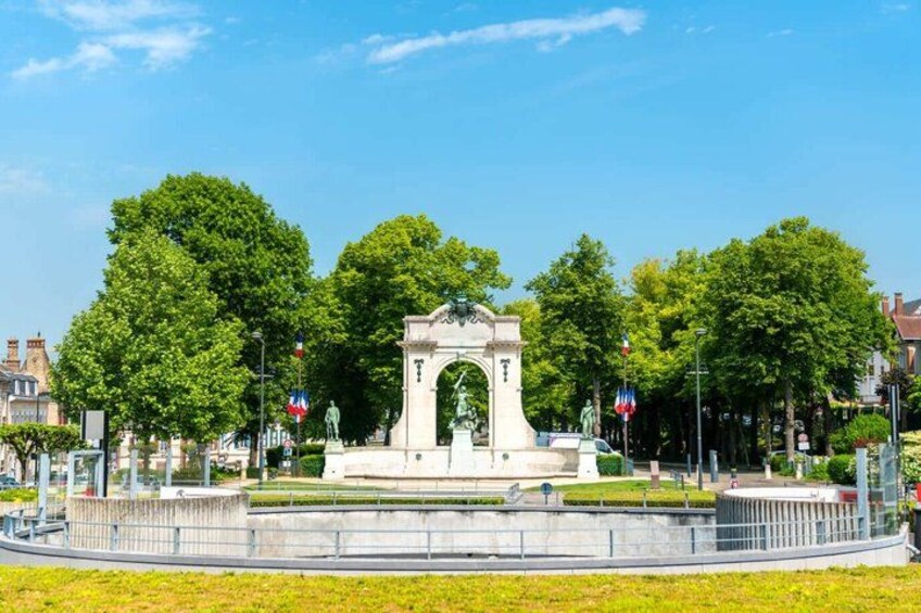A park with a central monument, surrounded by trees and a circular fence. 3