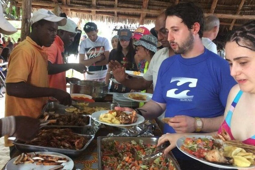 A group of people at a buffet with various dishes. 5