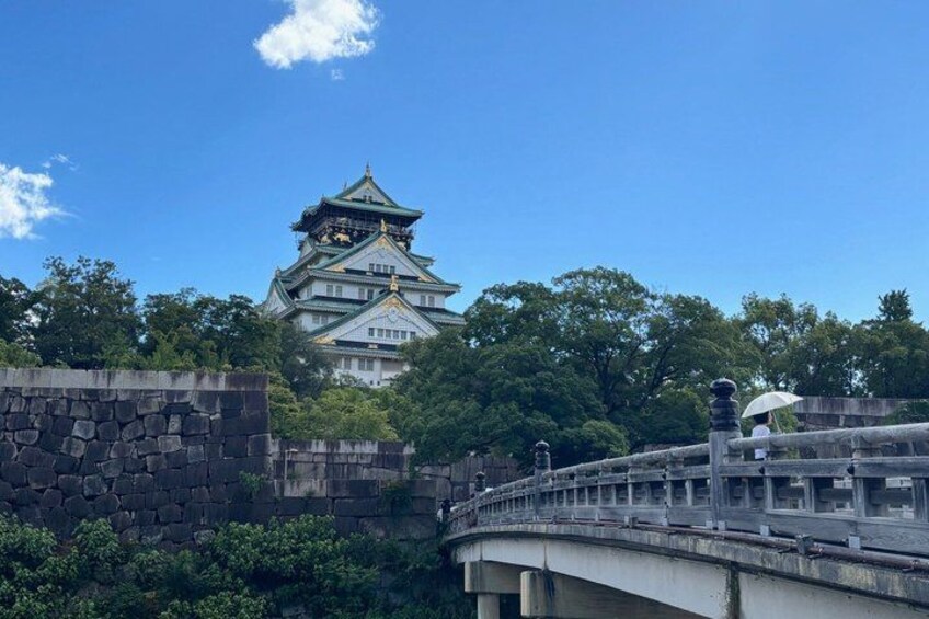 A stone wall, a bridge, and a traditional Japanese castle in the background. 2
