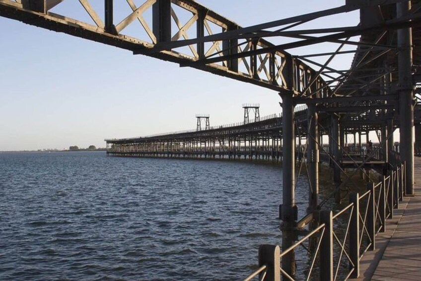 A pier extending into the water with a metal framework and wooden walkway. 2