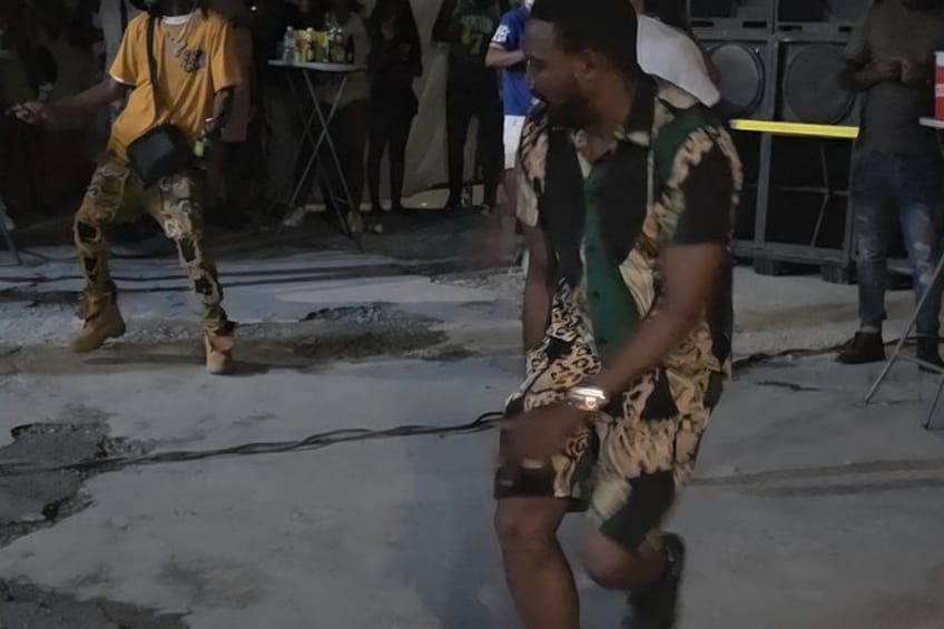 A person in a patterned outfit walking on a street. 3