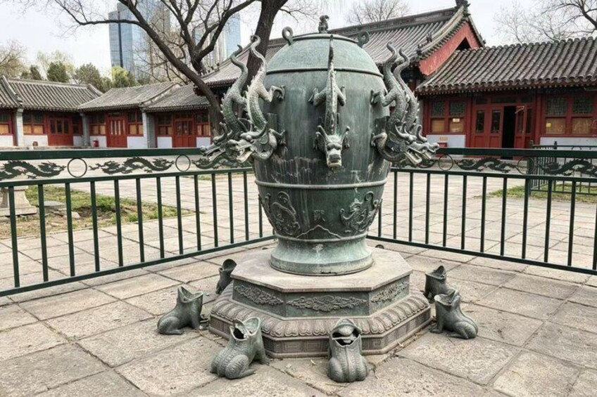 A traditional Chinese dragon statue on a pedestal, surrounded by a fence. 3