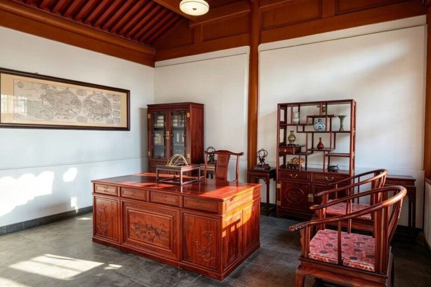A traditional wooden desk with intricate carvings, a matching chair, and a decorative cabinet. 5