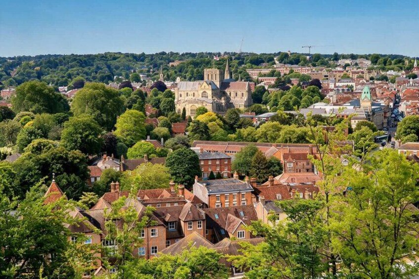 A town with historic buildings, a prominent church, and surrounding greenery. 1