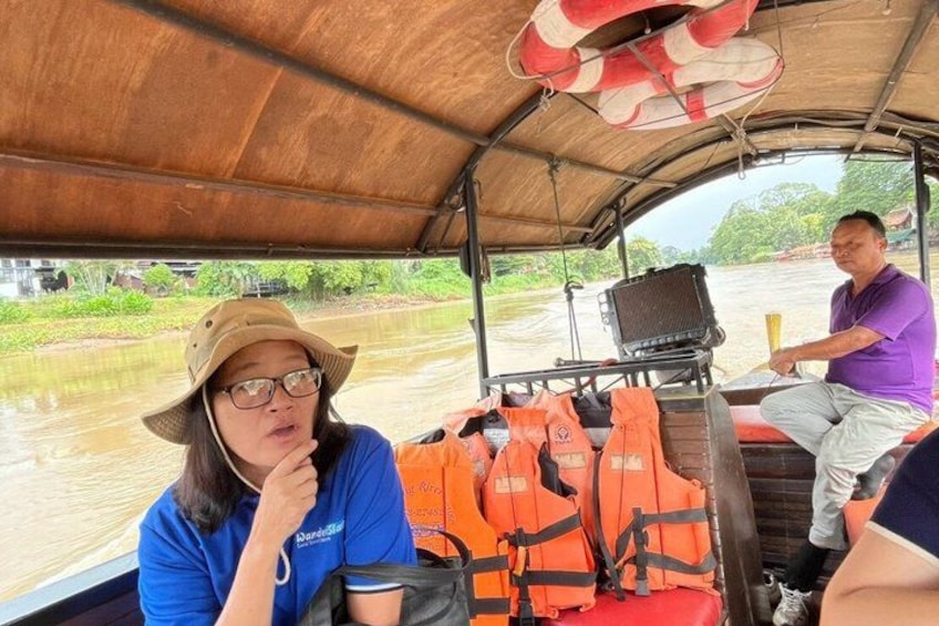 A boat with passengers wearing life jackets, a man driving, and a woman looking out the window. 5