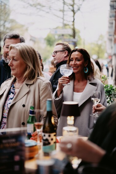 A group of people at an outdoor event, some holding drinks. 4
