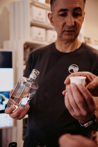 A person holding a bottle and a container. 2