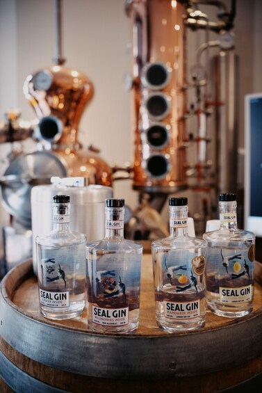 Four bottles of Seal Gin on a wooden barrel. 1