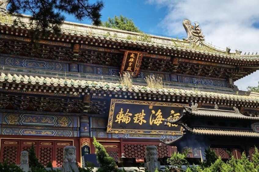 A traditional Chinese building with ornate decorations and a sign with Chinese characters. 3