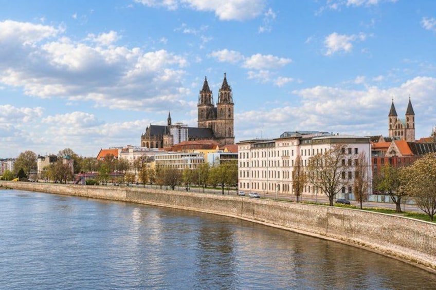 A river with buildings and a tower in the background. 2