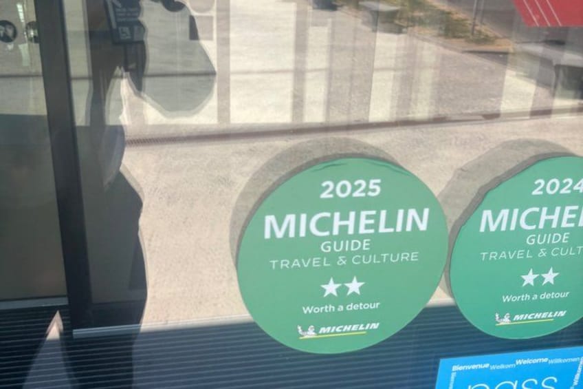 Two green circular signs with text and stars, placed on a reflective surface. 3