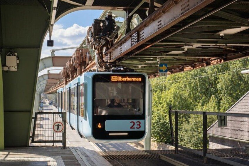 A blue train with the destination Oberbarmen, number 23, at a station. 2