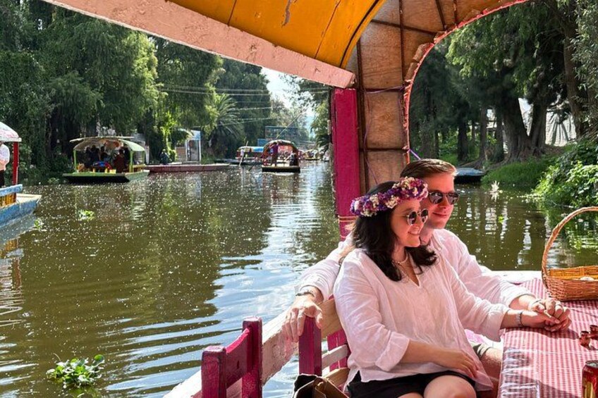 A river with boats, a covered area with a table, and greenery in the background. 2