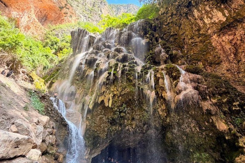 A multi-tiered waterfall cascading over rocky terrain with lush greenery. 4