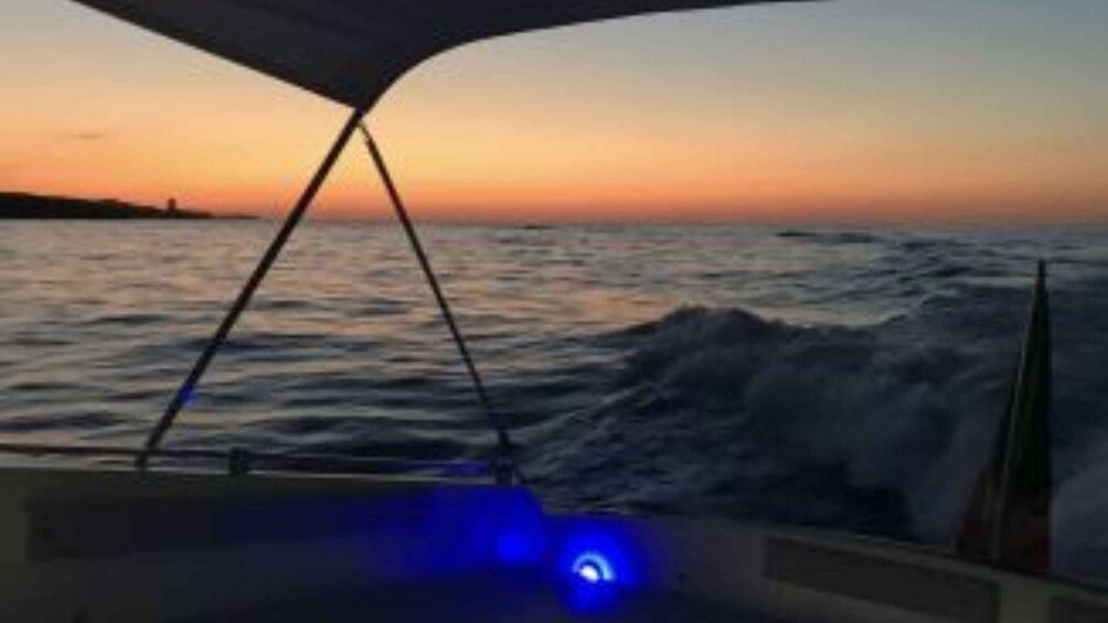 A boat at sunset with waves and a clear sky. 5
