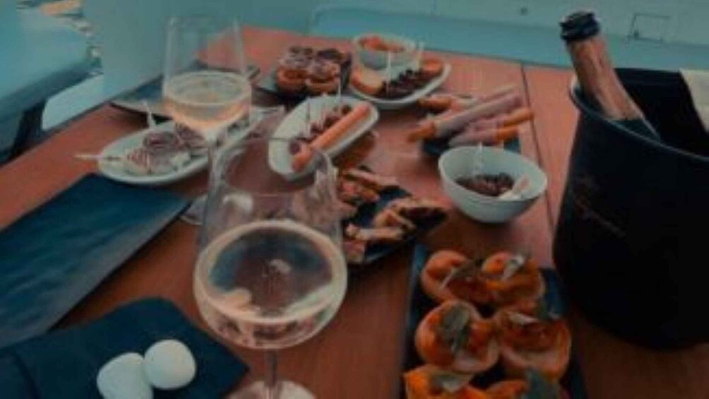 A table set with various dishes, glasses of wine, and a bottle of champagne. 4