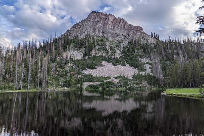 A mountain with a lake in the foreground reflecting the mountain. 1