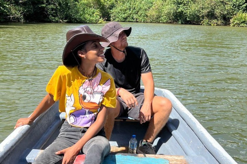 Two people in a boat on a river surrounded by greenery. 3