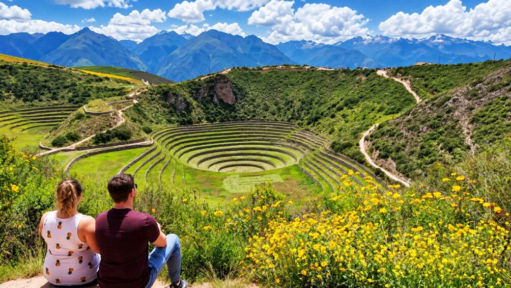 A couple sitting on a hill overlooking terraced fields and mountains. 2
