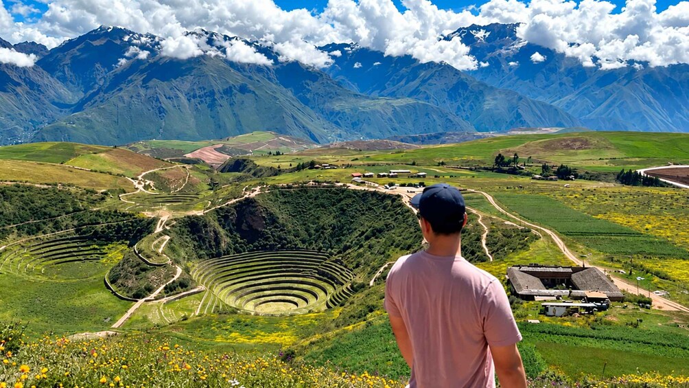 A person overlooking terraced agricultural fields with mountains in the background. 4
