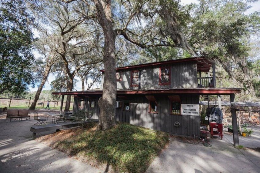 A rustic tasting room with a wooden exterior, surrounded by trees. 3