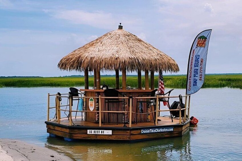 A wooden boat with a thatched roof, floating on calm water, surrounded by greenery. 3