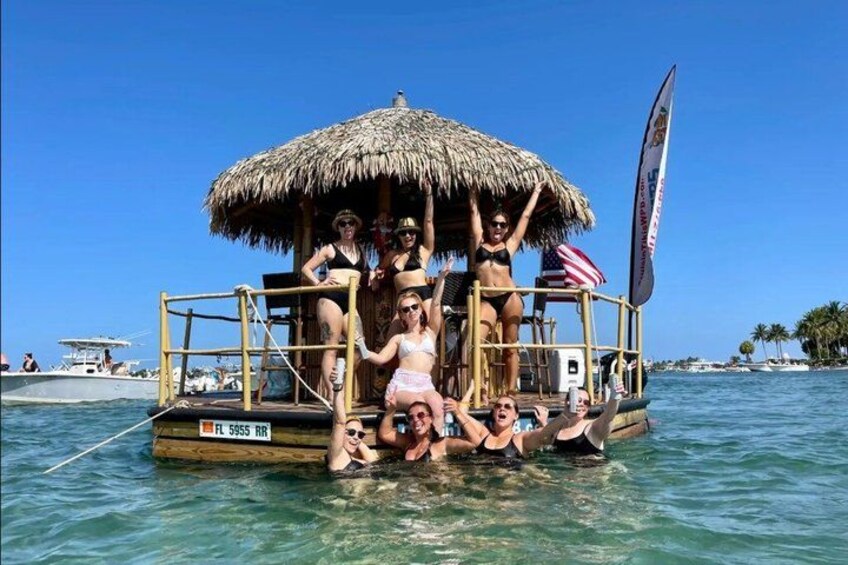 A boat with a thatched roof, people in swimwear, and an American flag. 4