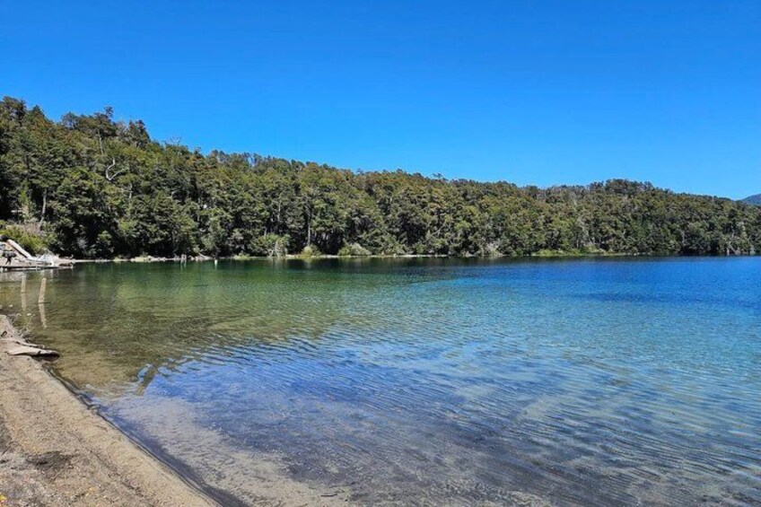 A clear lake surrounded by dense forest. 5