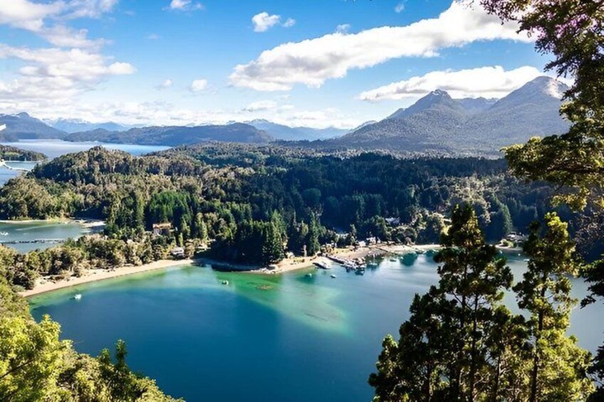 A lake surrounded by forested hills and mountains. 1