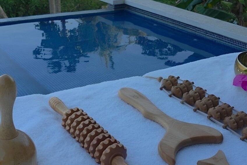 A poolside with wooden tools and a bowl on a white towel. 2