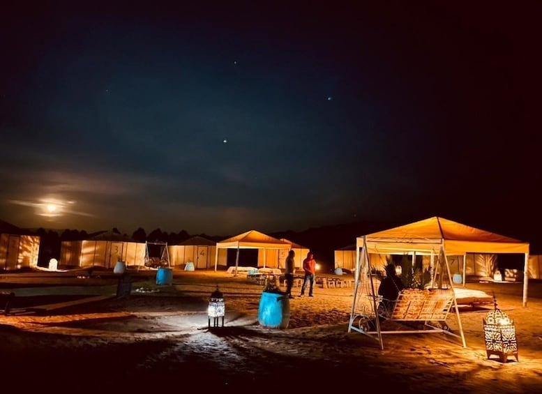 Ein Campingplatz bei Nacht mit Zelten und Laternen. 2