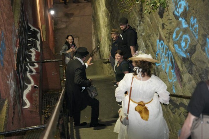 A group of people in a narrow alleyway with graffiti on the walls. 5