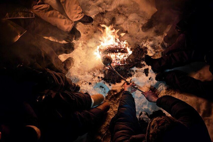 People sitting around a campfire in a circle. 5