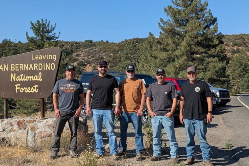 Five people standing in front of a sign that reads 'Leaving AN BERNARDINO National Forest.' 5