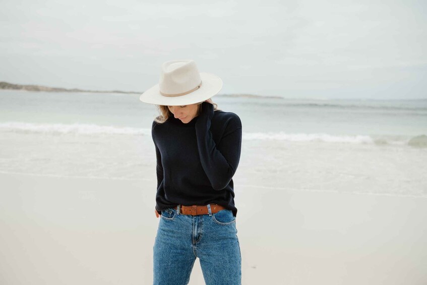 A person standing on a beach with waves in the background. 2