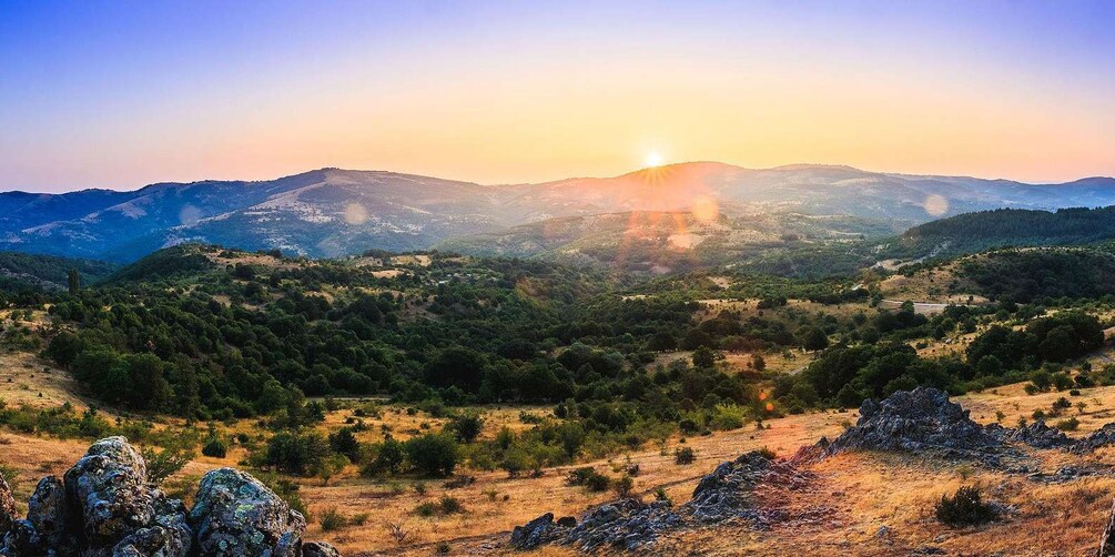 Un paysage montagneux, avec un lever de soleil, un terrain rocheux et une végétation clairsemée. 5