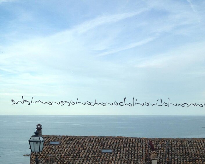 A coastal view with a tiled roof and a lamp post. 1