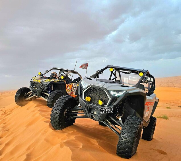 Two off-road vehicles on a sandy terrain with a cloudy sky. 5