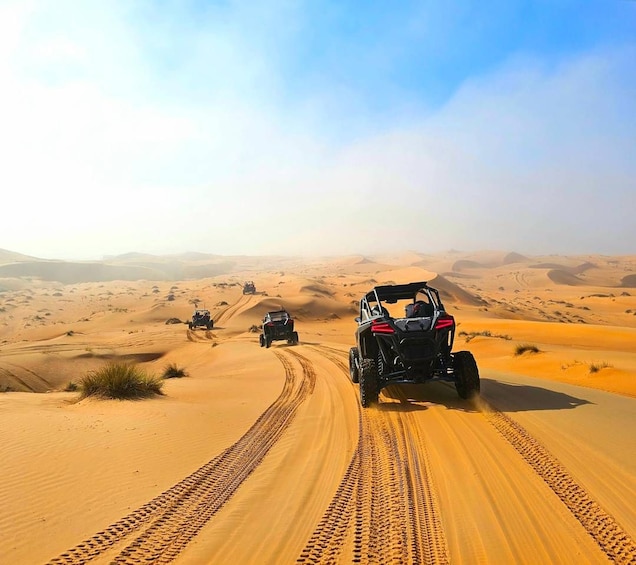 Off-road vehicles on a sandy trail in a desert landscape. 1