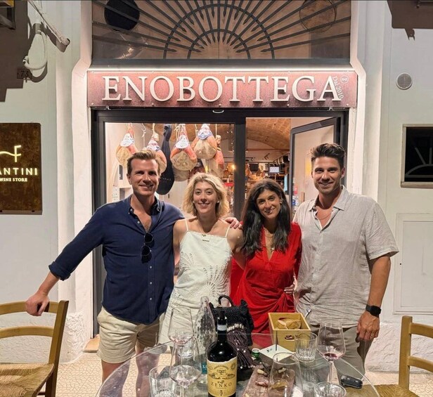 A group of people standing in front of a store named ENOBOTTEGA. 5
