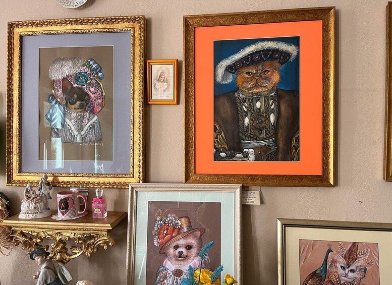 Un mur orné de divers tableaux encadrés, notamment des portraits d’animaux et des objets décoratifs. 4