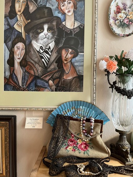 Un tableau encadré, un éventail décoratif et un vase rempli de fleurs. 5