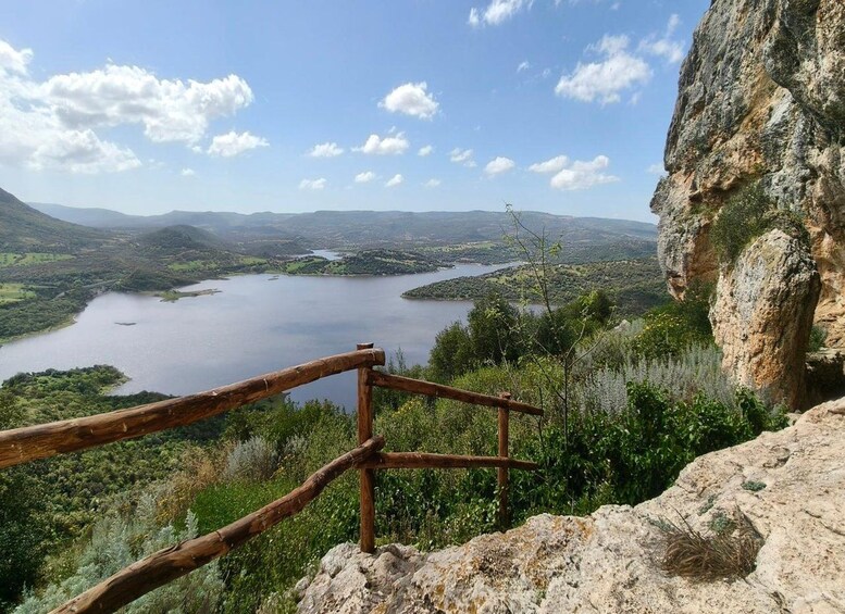 A wooden fence overlooking a lake surrounded by hills. 1