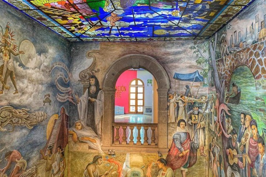 A stained glass window with a pink and white design, surrounded by detailed murals depicting various figures and scenes. 1
