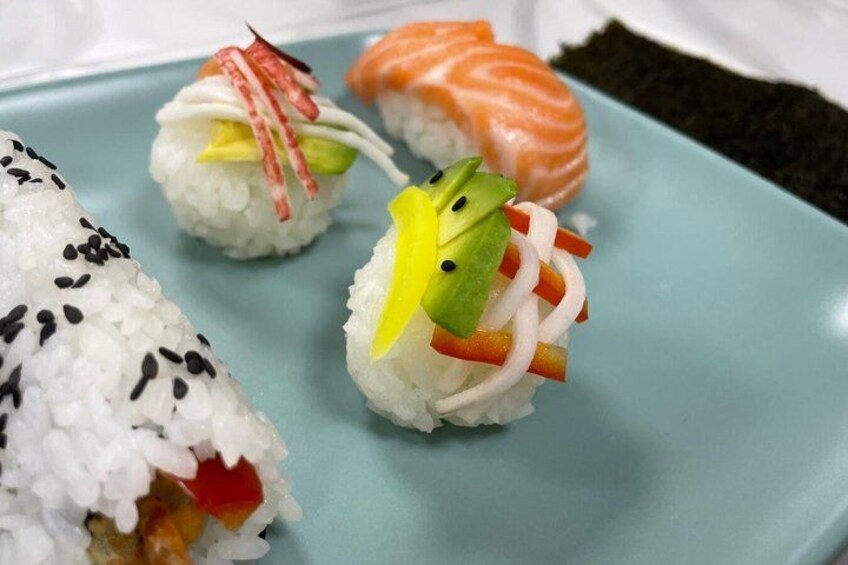 Sushi on a blue plate with a piece of salmon and a vegetable roll. 4