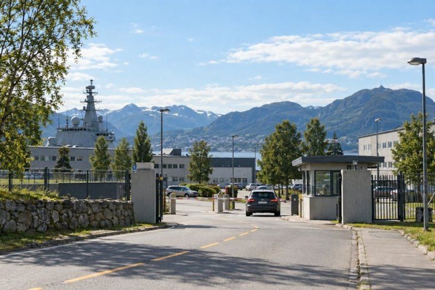 A road leading to a gated entrance with a mountain backdrop. 4
