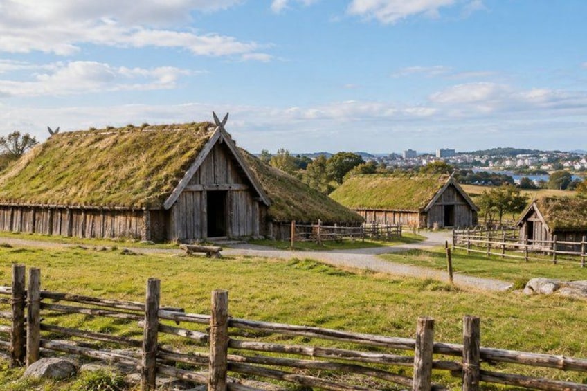 A rural landscape with thatched-roof buildings and a wooden fence. 3