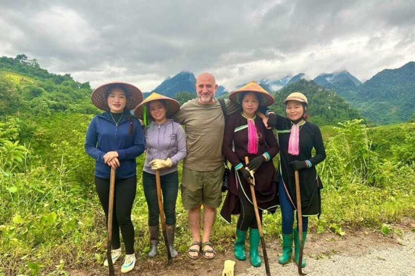 A group of people standing on a path with a mountainous landscape in the background. 1