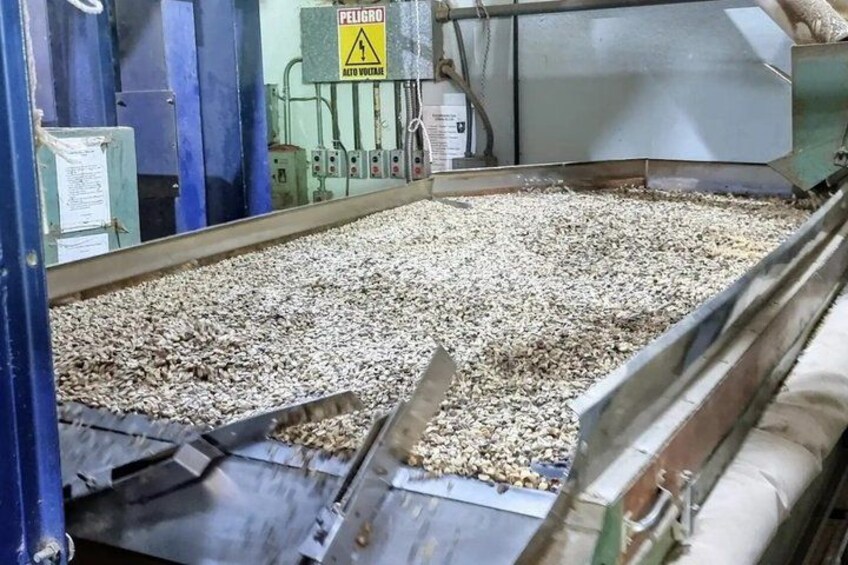 A machine processing materials, with a warning sign and control panels visible. 2